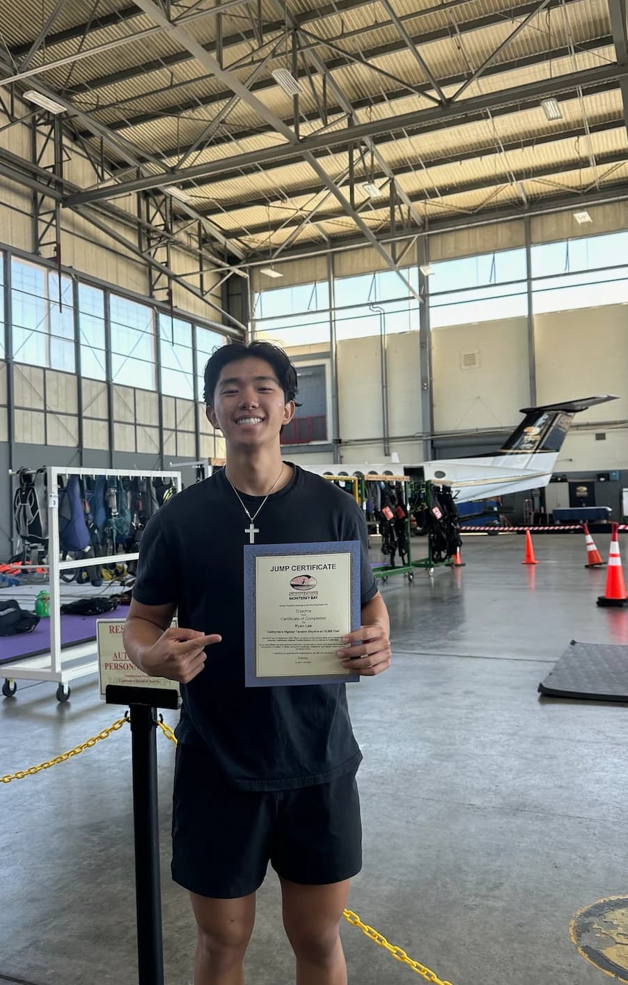 Ryan holding his skydiving jump certificate