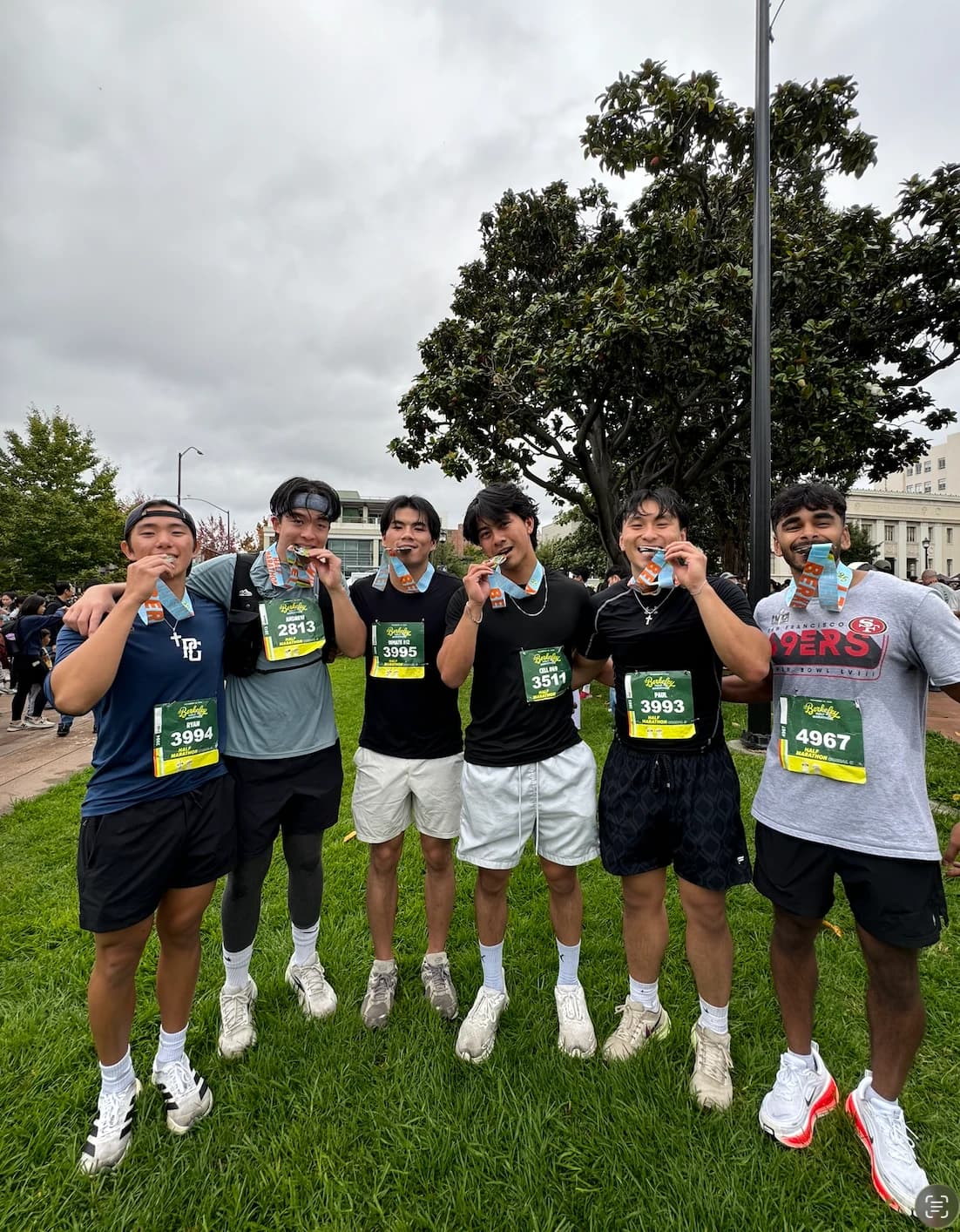 Ryan and friends biting their half marathon medals