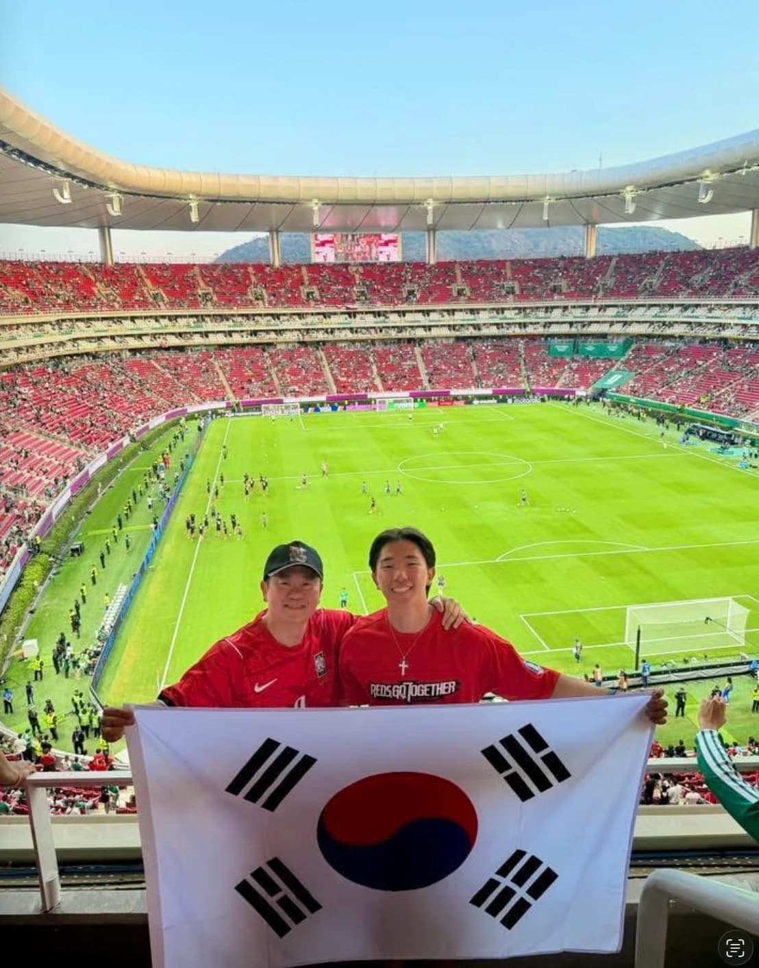 Ryan holding a South Korea flag at a soccer match